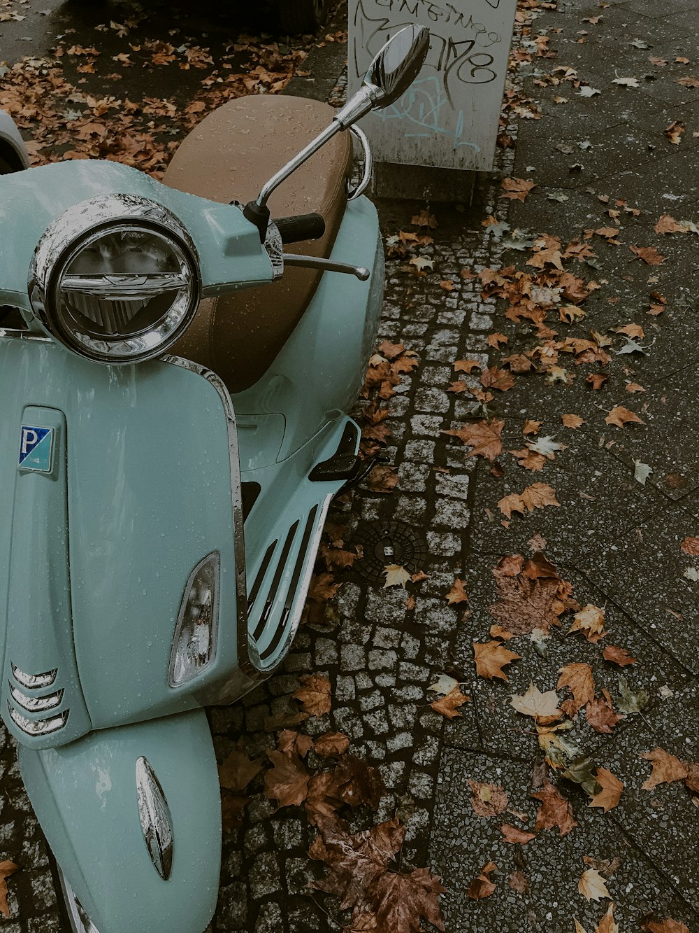 blue and silver motor scooter on brown and gray concrete floor