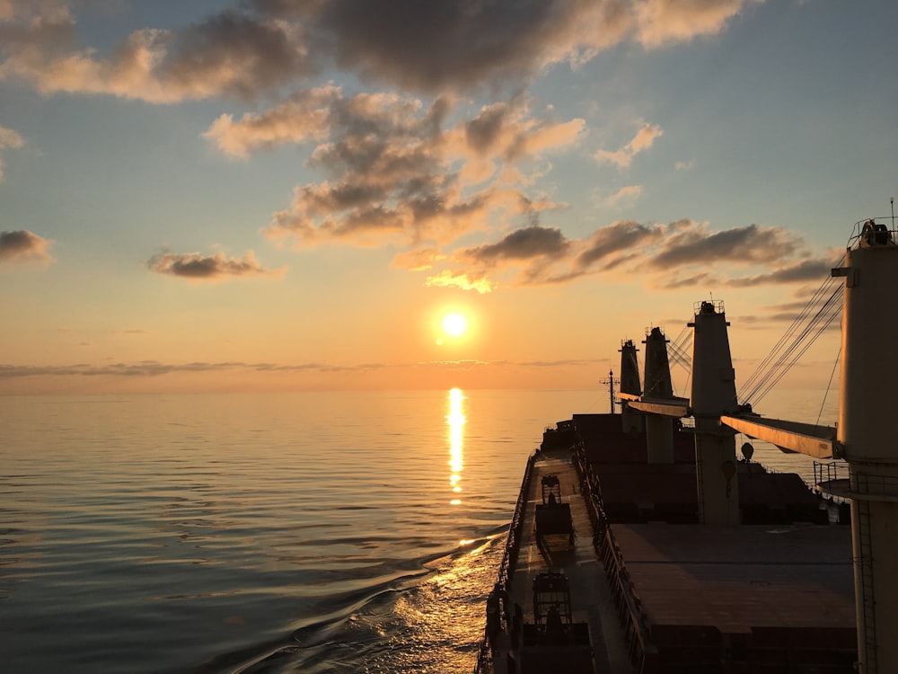 silhouette of a person standing on a dock during sunset