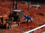 man in blue jacket and blue denim jeans holding brown wooden stick