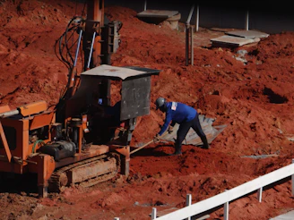 man in blue jacket and blue denim jeans holding brown wooden stick