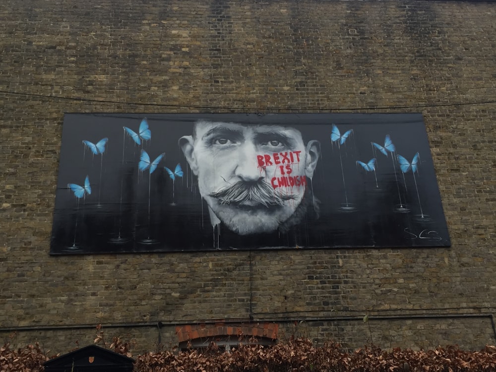 black and white graffiti on brown brick wall