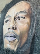 A detailed and realistic mural featuring the face of a man with dreadlocks and a contemplative expression. The artwork is rich in texture, capturing the intricate details of the hair and facial features.