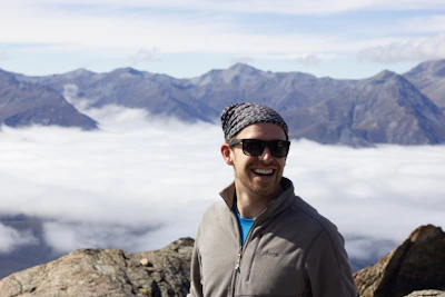 Close-up of a participant’s joyful face, framed by a colorful scarf and mountain backdrop.