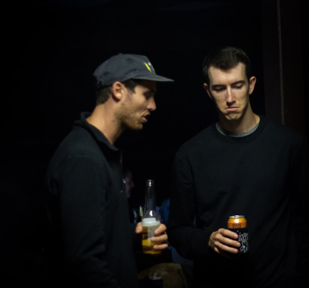 man in black crew neck long sleeve shirt standing beside man in black crew neck shirt