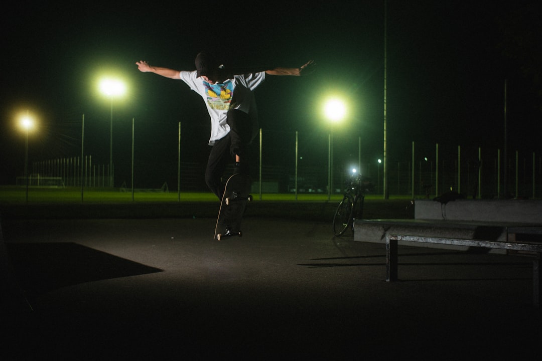 man in white shirt and black pants jumping on the street during night time