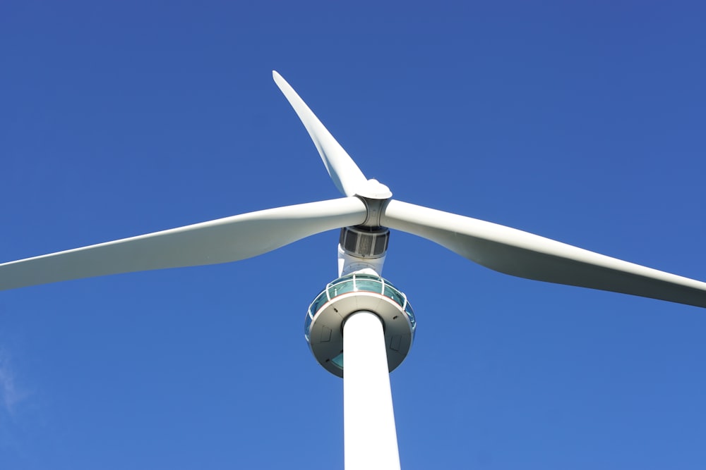 white and gray wind turbine under blue sky during daytime