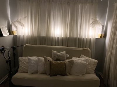 Cozy studio corner with cream walls, gold accents, and a vintage microphone.