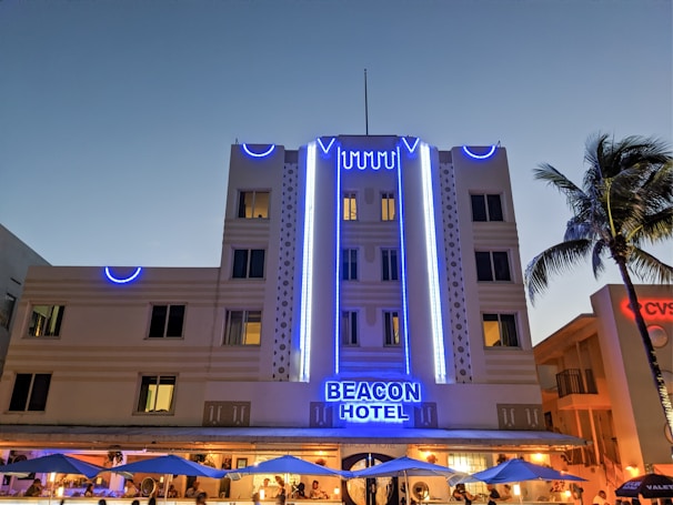 Elegant entrance of The Beacon Club with the golden beacon logo glowing softly at dusk.