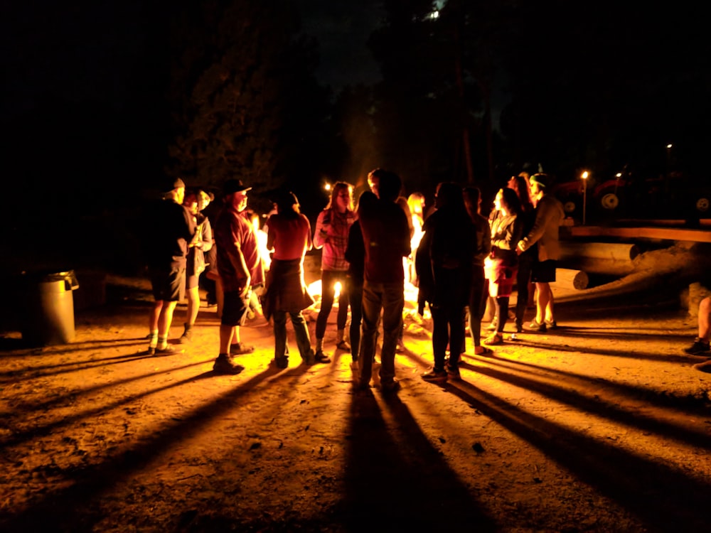 group of people walking on road during nighttime