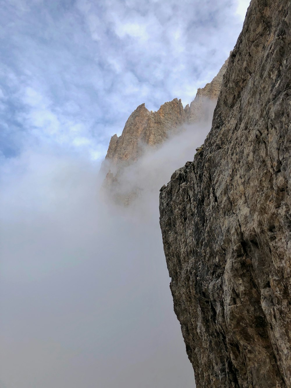 gray rocky mountain under white clouds during daytime