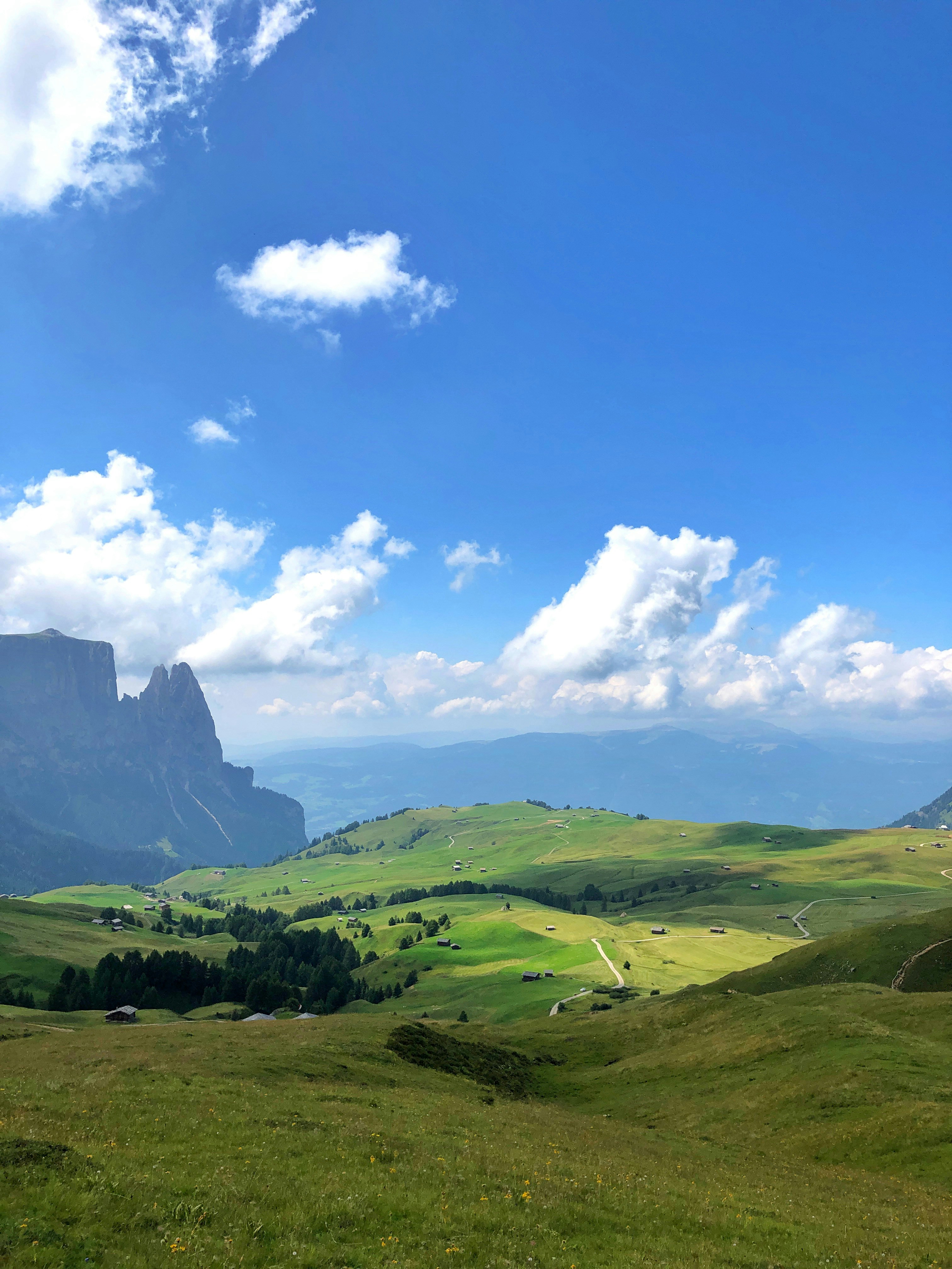 Green grass field and mountain under blue sky and white clouds during ...