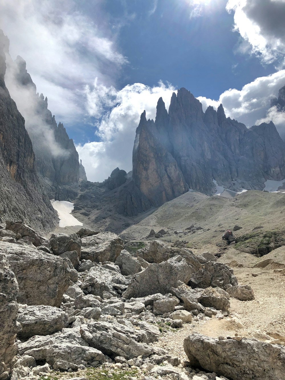 rocky mountain under blue sky and white clouds during daytime