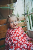 A joyful child wearing a bright firadosis hair bow outdoors.