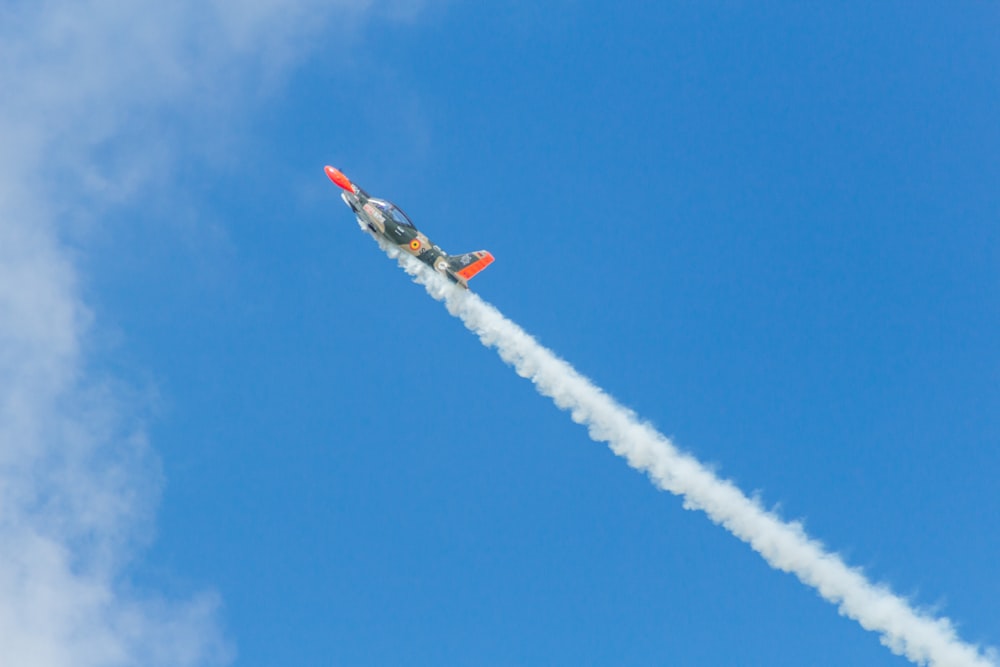 red and white jet plane in mid air during daytime