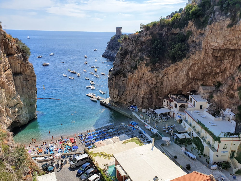 aerial view of boats on sea near mountain during daytime