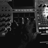 Close-up of hands on a MIDI controller crafting a new trap beat.