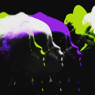 A series of overlapping, silhouetted profiles create a sense of motion and depth, with vibrant green and purple highlights. The profiles emerge from a dark background, accentuating the contrasting colors.