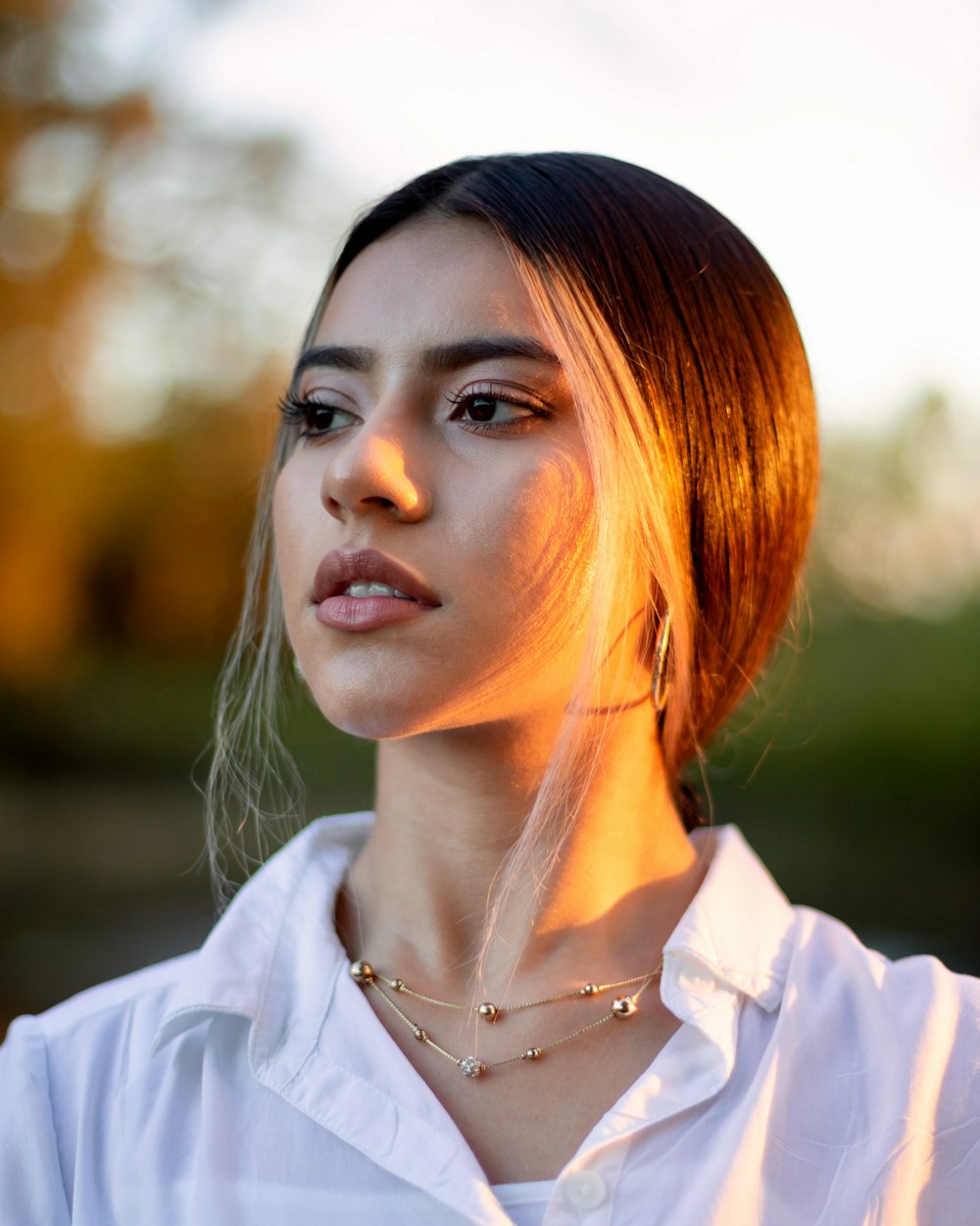 woman in white button up shirt wearing silver necklace