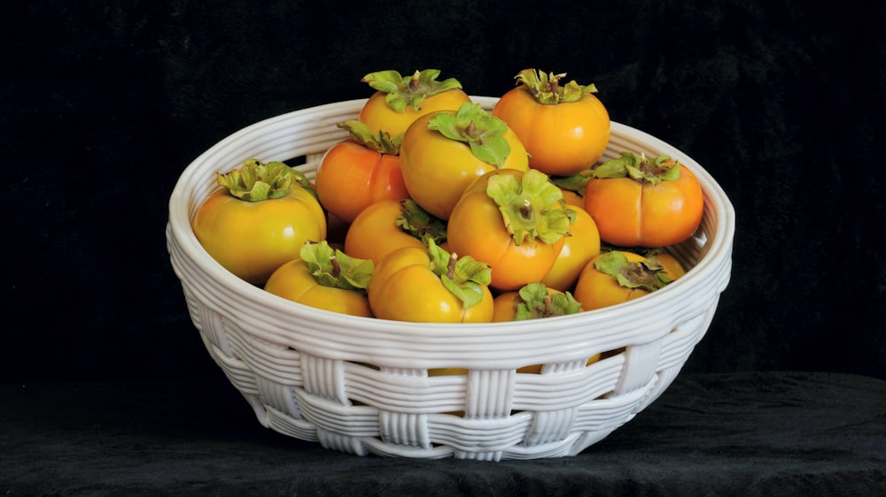 yellow and orange bell peppers in white woven basket