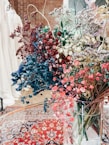 A vibrant arrangement of dried flowers in a decorative vase on a soft beige background.