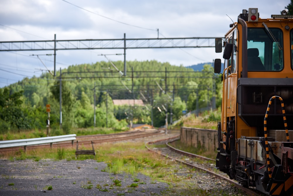 yellow and black train on rail tracks during daytime