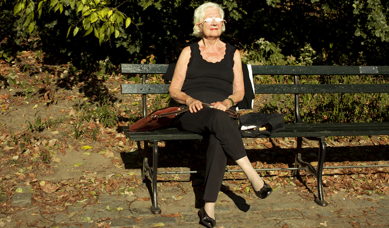 woman in black tank top sitting on brown wooden bench