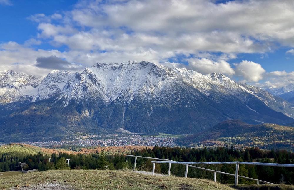 green grass field near snow covered mountain during daytime