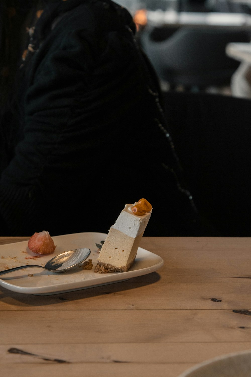 person in black long sleeve shirt holding white ceramic plate with food