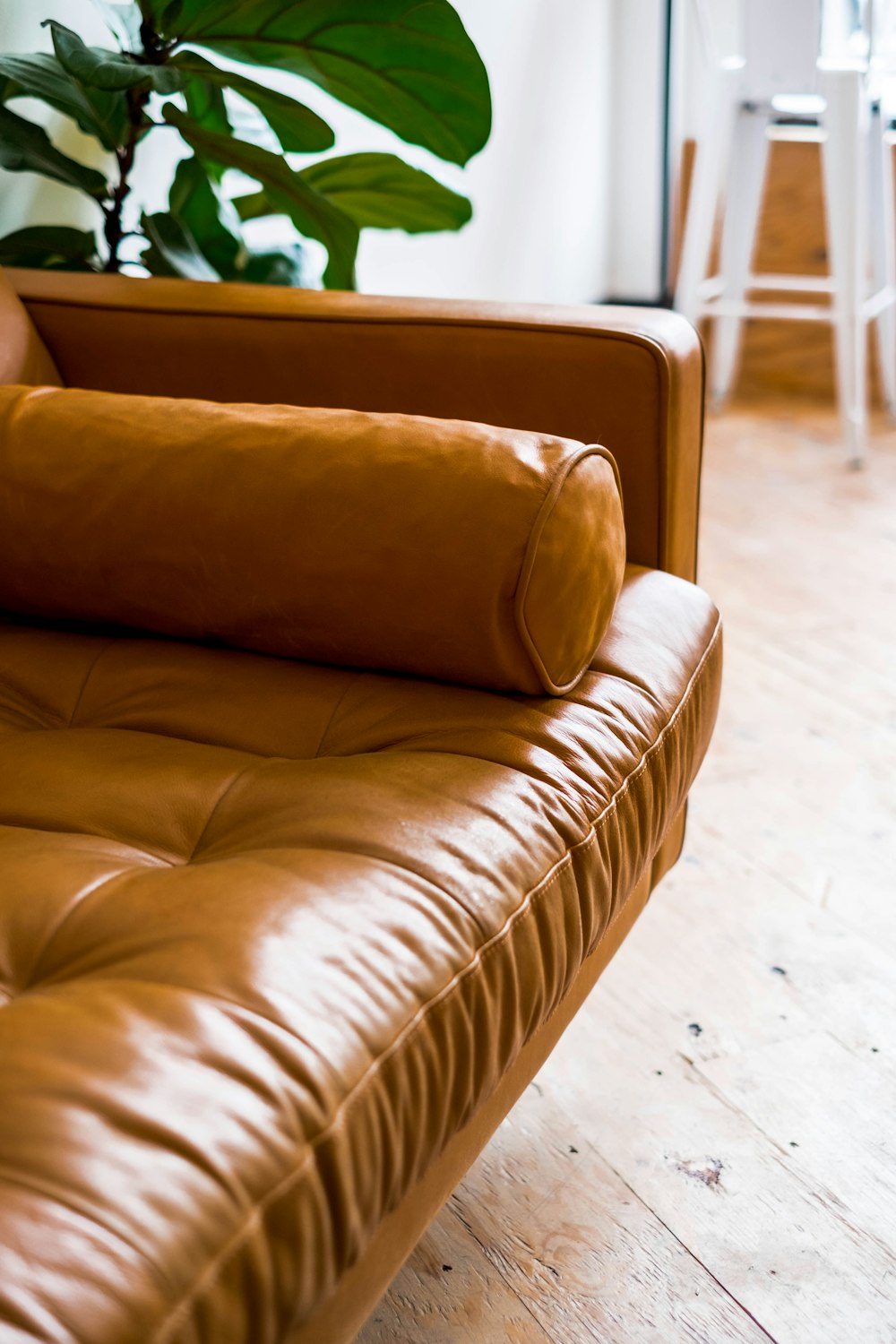 brown leather couch on white ceramic floor tiles