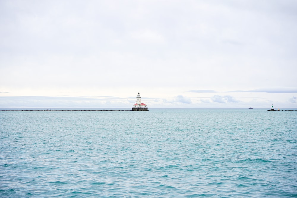 white and red boat on sea under white sky during daytime