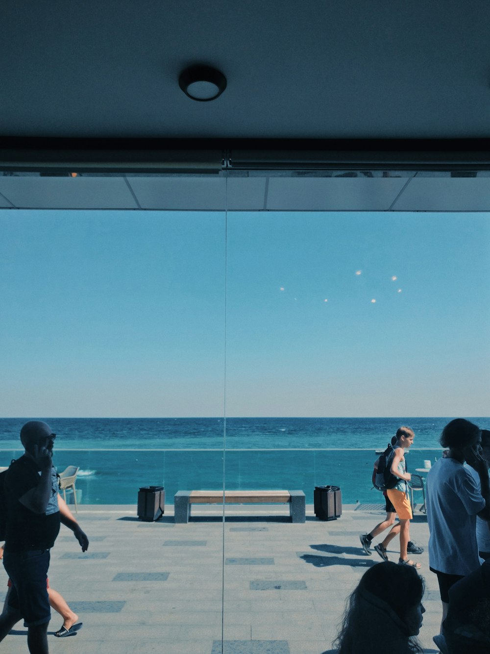 people sitting on bench near sea during daytime