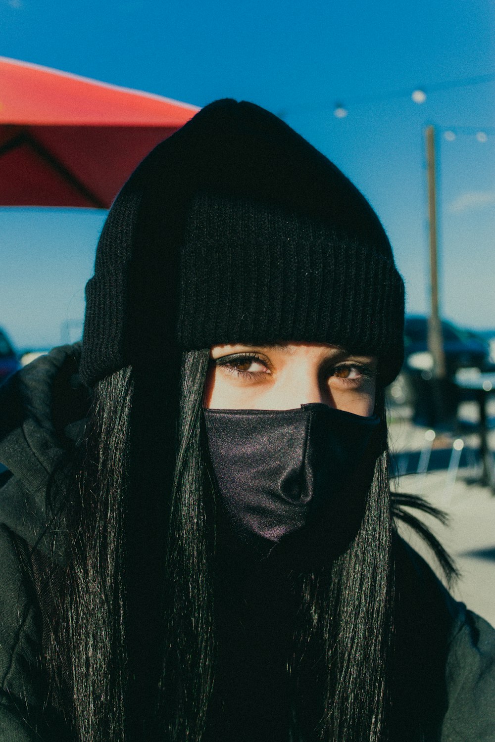 person in black hijab standing near red and blue wall