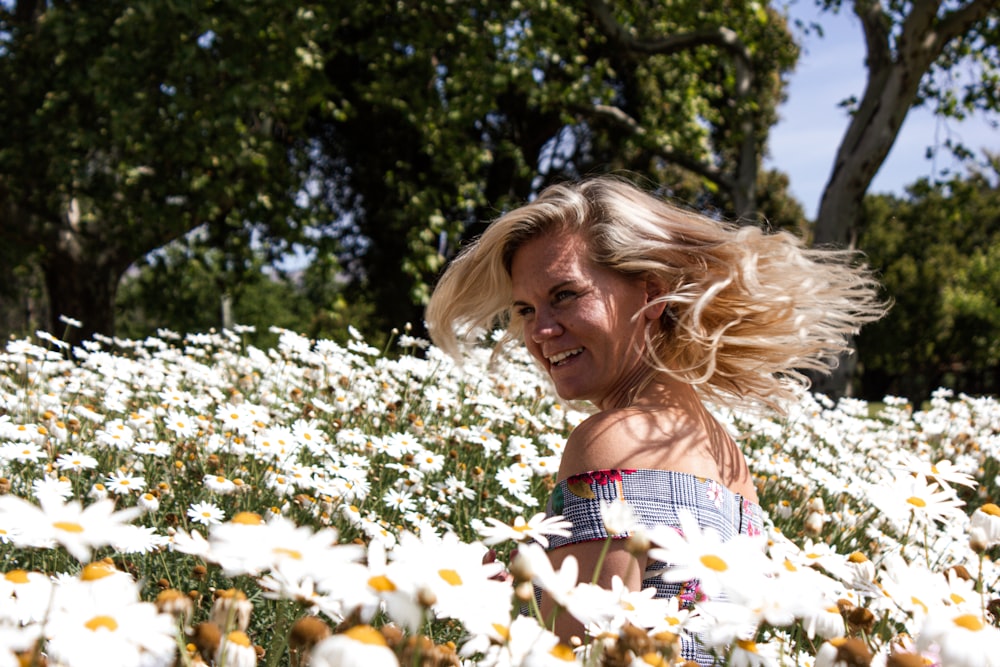 woman in white and red floral tube dress standing on white flower field during daytime