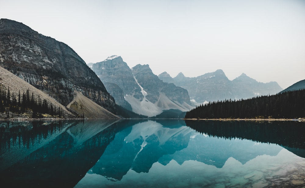 lake near mountain range under blue sky during daytime