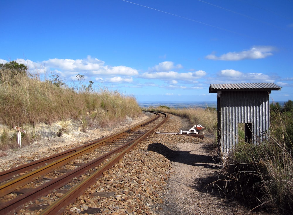 brown wooden train rail under blue sky during daytime