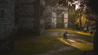 A lively group of primary school children exploring a historic castle on a sunny day.