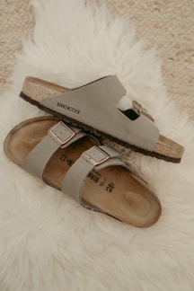 A clean, minimalist layout showcasing Birkenstock soft footbed sandals with ample white space around the product.