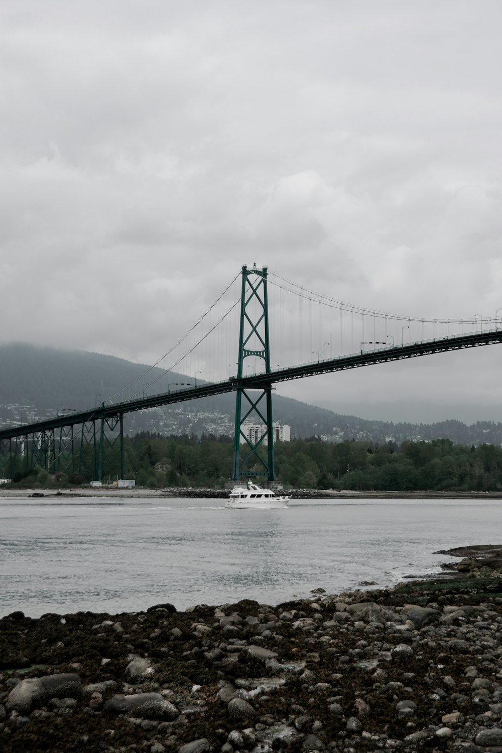 gray bridge over the sea under white sky during daytime