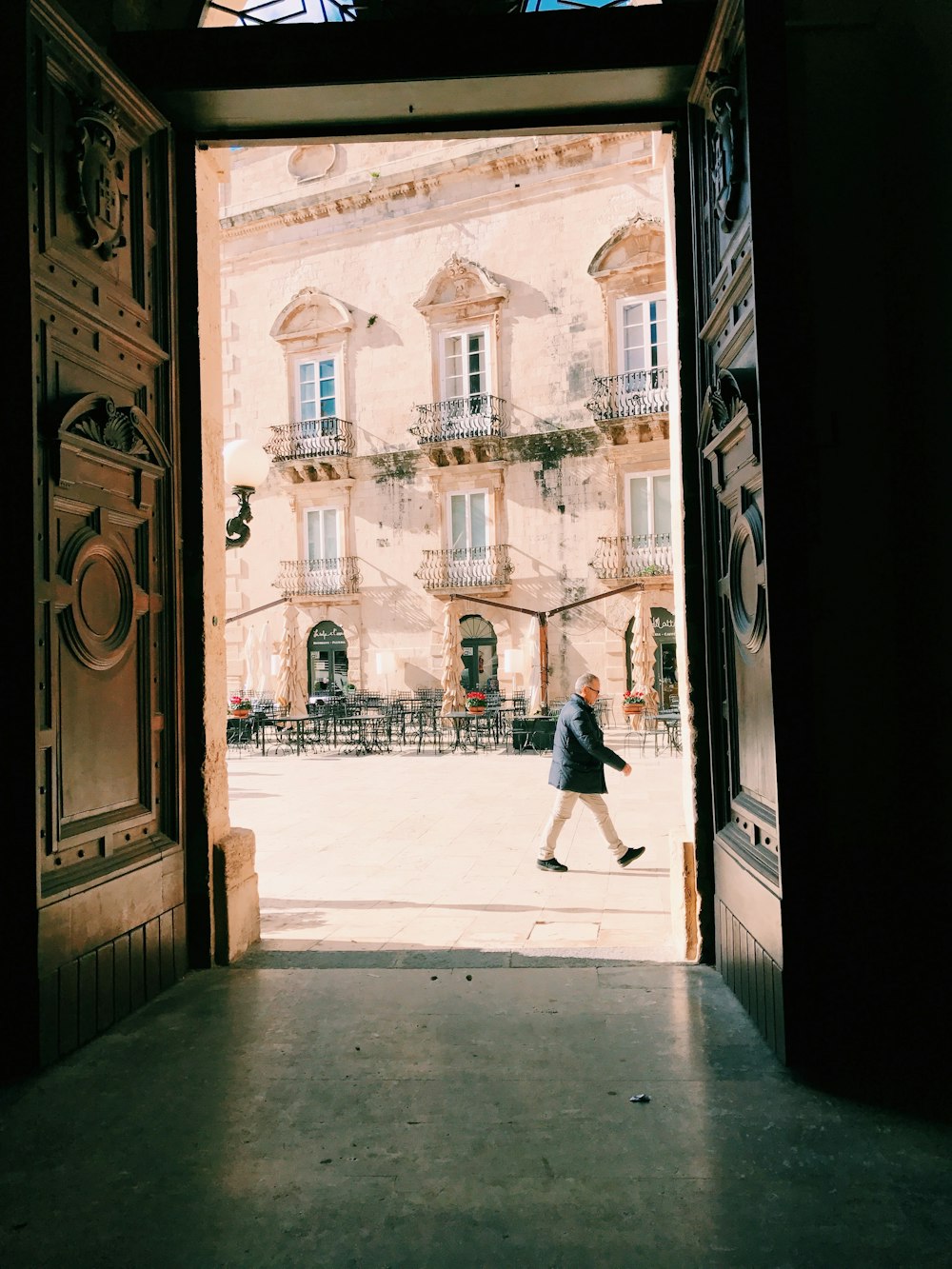 woman in black dress walking on sidewalk during daytime