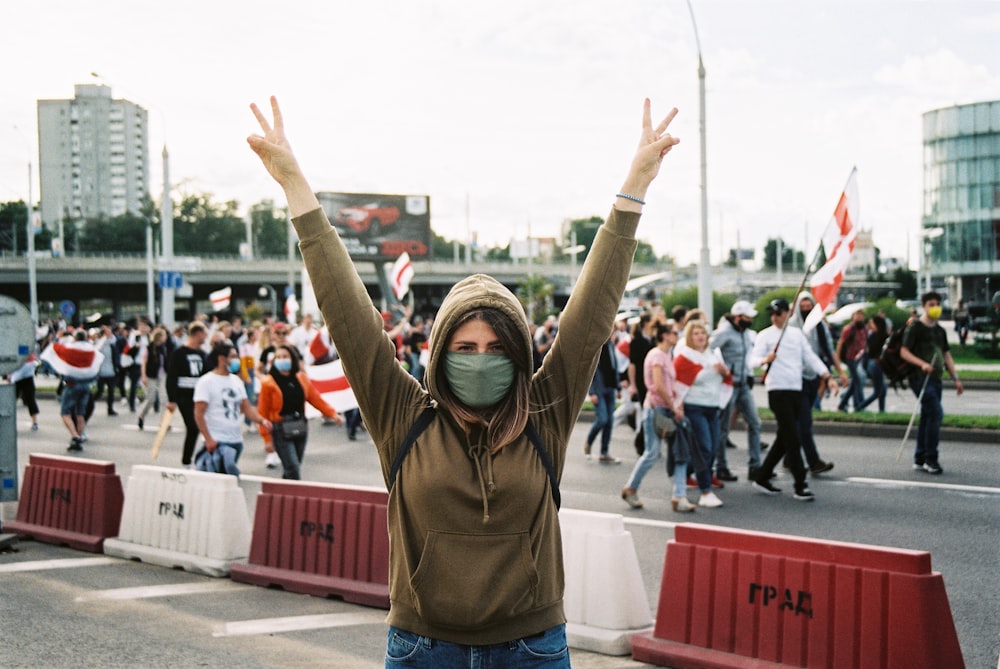 woman in brown hoodie raising her hands