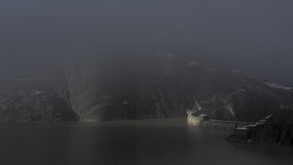 white ship on body of water near mountain during daytime