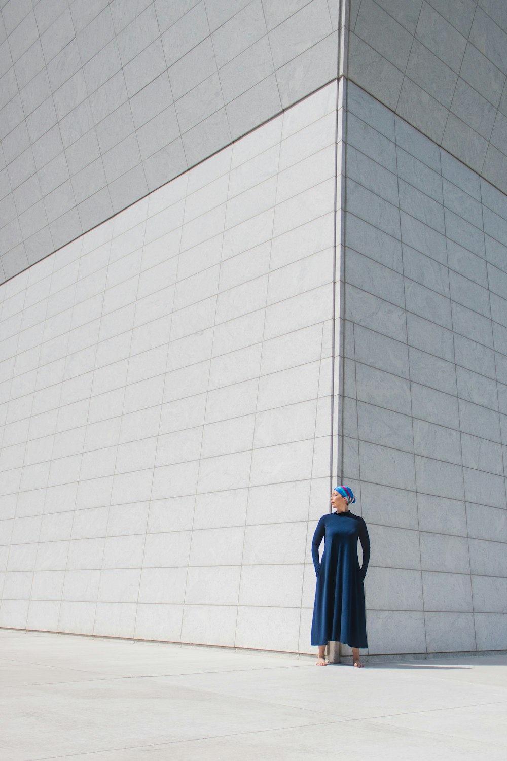 blue umbrella leaning on white wall