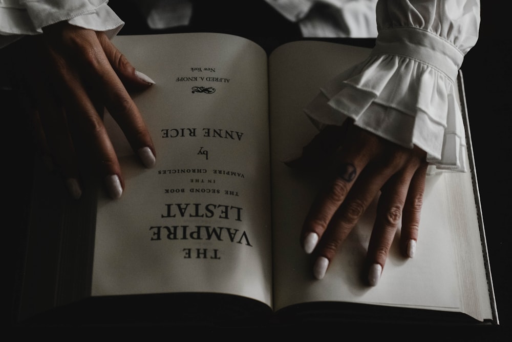 a woman's hands holding an open book