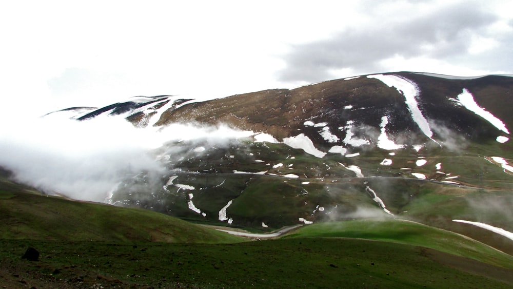 green grass field near mountain during daytime