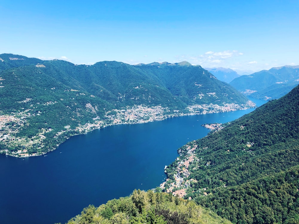 green mountains near body of water under blue sky during daytime