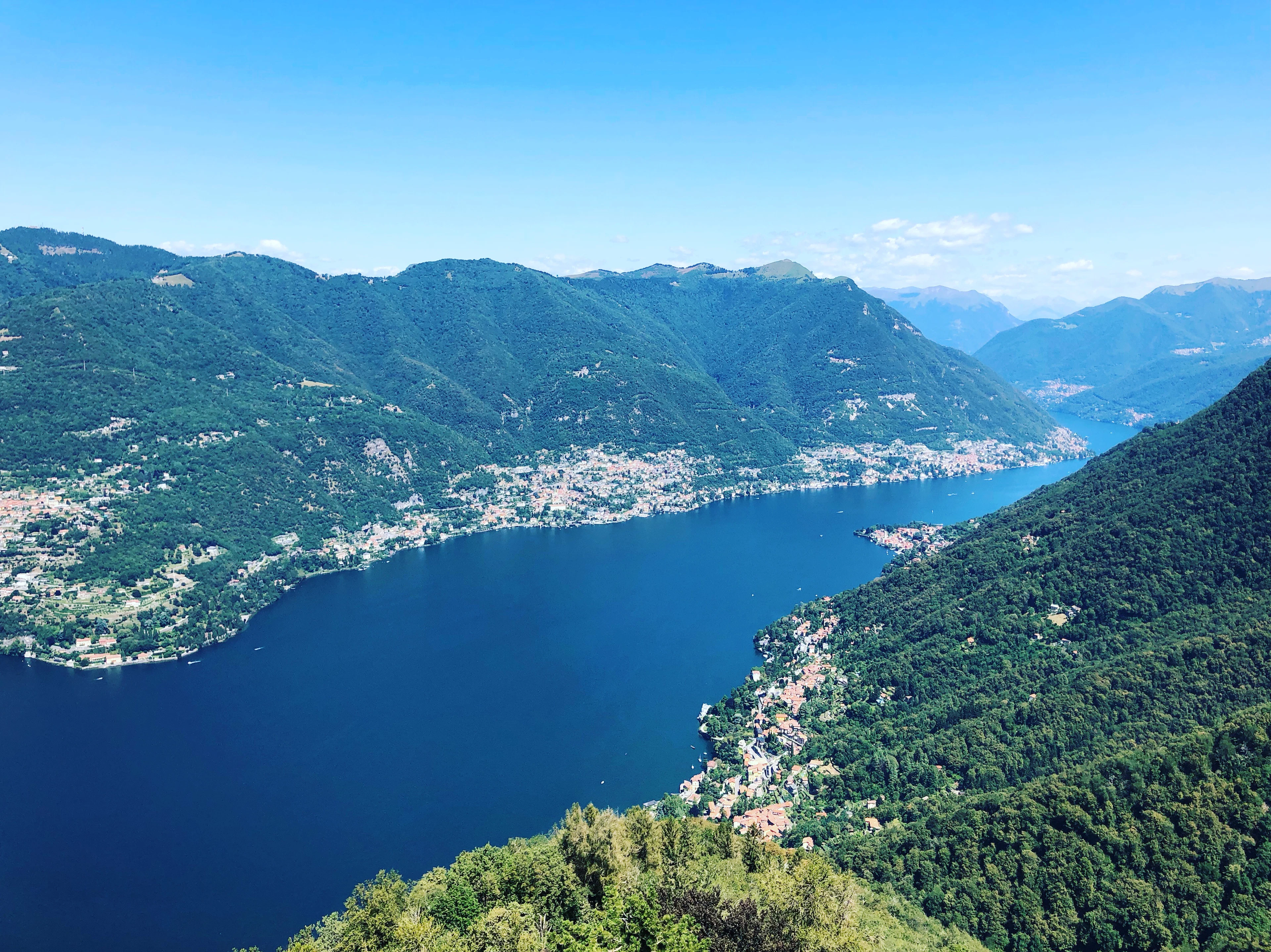 Lake Como seen from the mountains, with villages along its wooded shores