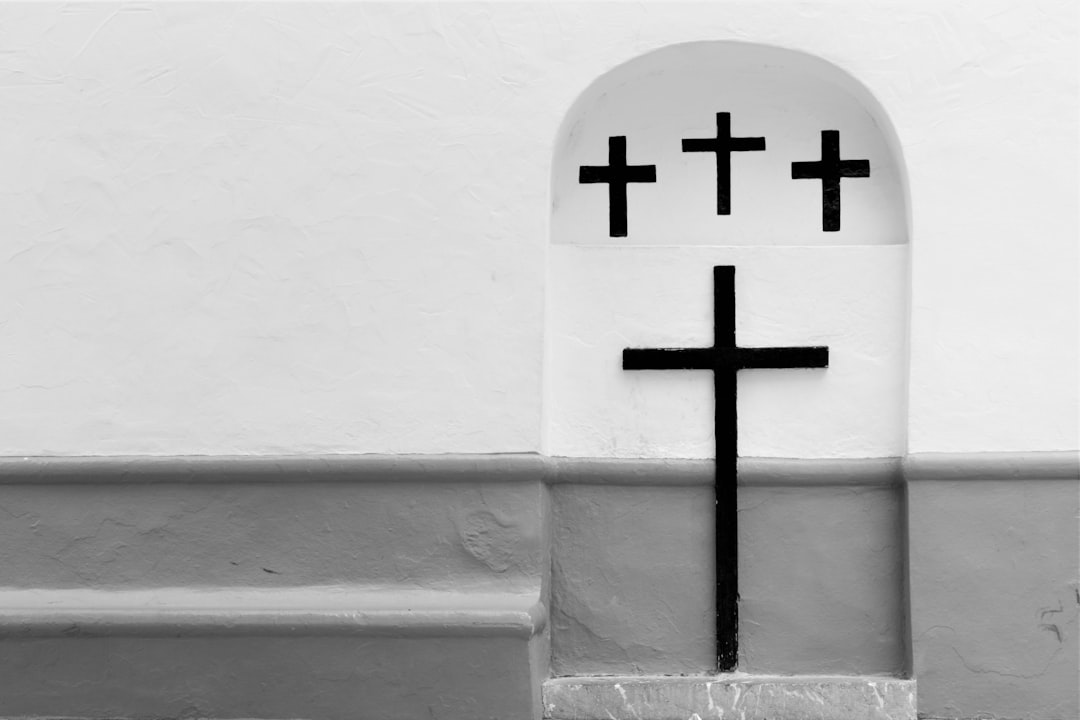 cross on white concrete wall