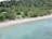 A serene beach with crystal-clear water and palm trees, inviting travelers to relax and enjoy their vacation.