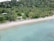 A serene beach with crystal-clear water and palm trees, inviting travelers to relax and enjoy their vacation.