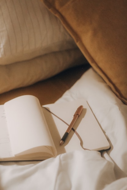 A warm, inviting photo of a woman journaling in a cozy sunlit room, symbolizing reflection and personal growth.